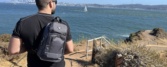 a man looking out at the water wearing Erozul Equinox Smell Proof Sling Bag