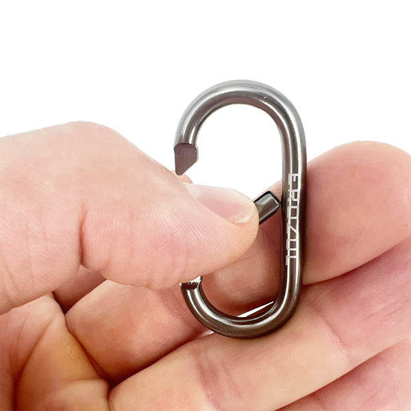 A hand holds an Erozul Aluminum Anodized Snap Hook Keyring Carabiner with a spring-loaded gate between the thumb and index finger—ideal for everyday carry.