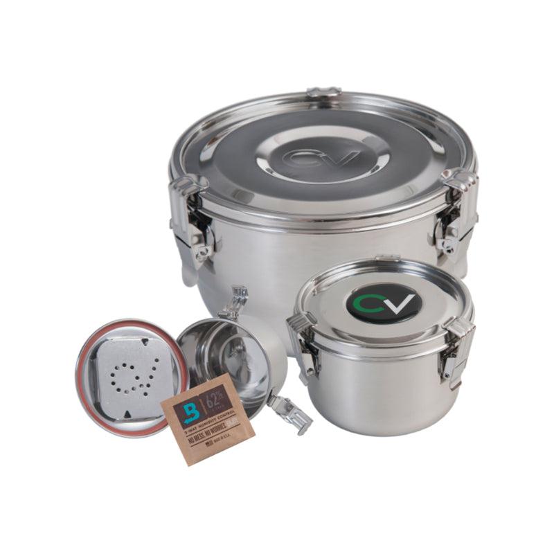 Three stainless steel storage containers of varying sizes with latch closures, shown with an opened lid, a humidity pack, and a perforated insert.